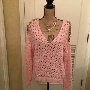 O diet Amo pink knit sweater with gold chain on shoulders.